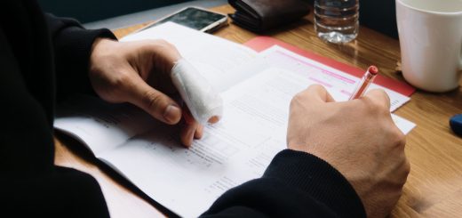 man with an injured finger signing a document